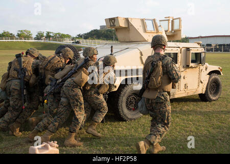 Marines Push ein Humvee 5 Dez im Camp Hansen während der ersten jemals Caltrap herausfordern. Die Herausforderung gegeneinander Teams in einer Vielzahl von Hindernissen und Veranstaltungen fördern Wettbewerb innerhalb der Abteilung und testen die Marines Kompetenz innerhalb des physischen, Militärs, psychische und Führung reichen. Die Marines sind mit 1. Bataillon, 1. Marineregiment, 3. Marineabteilung, III. Marine Expeditionary Force, derzeit unter der Einheit-Deployment-Programm zugewiesen. (Foto: U.S. Marine Corps CPL. Matt Myers/freigegeben) Marines komplett zermürbenden Caltrap Herausforderung 141205-M-RS352-003 Stockfoto