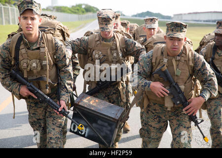 Marines tragen eine 70-Pfund-Munition kann während einer 6-Meilen-Wanderung 5 Dez im Camp Hansen während der ersten Caltrap-Challenge. Die Herausforderung gegeneinander-Teams in einer Vielzahl von Hindernissen und Veranstaltungen fördern Wettbewerb innerhalb der Abteilung und testen die Marines Kompetenz innerhalb des physischen, Militärs, psychische und Führung reichen. Die Marines sind mit 2. Bataillon, 3. Marine Regiment, 3. Marineabteilung, III. Marine Expeditionary Force. (Foto: U.S. Marine Corps CPL. Matt Myers/freigegeben) Marines komplett zermürbenden Caltrap Herausforderung 141205-M-RS352-004 Stockfoto