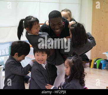 Lance Cpl. Kyle Thatch spielt eine Spiel mit Studenten von St. Pauls Elementary School in Pohang, Südkorea. Das Treffen wurde auf gebracht, durch eine freiwillige Möglichkeit für die Marines und Matrosen des 2. Bataillons, 9. Marine Regiment, die derzeit in der Republik Korea für koreanische Marine Austauschprogramm 15-15 bereitgestellt werden. Die Zeitspenden unterstützt die Umgebung außerhalb der Lager Mujuk und bessere Gemeinschaftsbeziehungen gebaut. Rasenfilz ist eine Mortarman mit Firma E, 2. BN, 9. Marines, 3. Marineabteilung, III. Marine Expeditionary Force, derzeit unter der Einheit Bereitstellung Progr zugewiesen Stockfoto