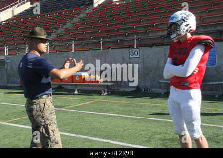 Staff Sgt Victor Rodriguez, Drill Instructor, Marine Corps zu rekrutieren Depot San Diego, spricht mit Brian Lewerke, ein Quarterback von Pinnacle High School in Phoenix im Team Training im Santa Ana Stadion hier heute als Bestandteil des Marine Corps 2015 Semper Fidelis All-American Bowl. Wie das Marine Corps verlangt die Semper Fidelis Fußball-Programm Qualität des Charakters, Exzellenz in Bildung und bewährte körperliche Fitness. Die Schüssel wird auf nationaler Ebene live vom StubHub Center in Carson um 18:00 (PST) am 4. Januar 2015, auf Fox Sports 1 im Fernsehen übertragen werden. (Offizielle Marinekorps Foto von CPL. Francisco Stockfoto