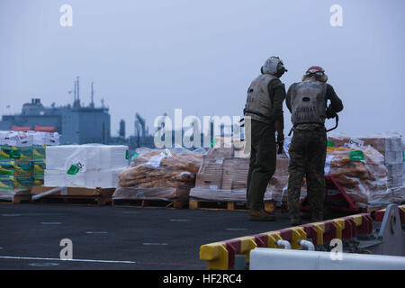 US-Marines aus dem 11. Marine Expeditionary Unit (MEU) zugewiesen die Bekämpfung Cargo Division der amphibischen Angriff Schiff USS Makin Island (LHD 8), eine Palette von Lebensmitteln während bewegen ein laufenden Nachschub an Bord der USS Makin Island, 6. Januar 2014. Die 11. MEU wird als ein Theater Reserve und Krise Reaktionskräfte im gesamten US Central Command und 5. Flotte Verantwortungsbereich mit Makin Island amphibische bereit Group bereitgestellt. (Foto: U.S. Marine Corps CPL. Evan R. White/freigegeben) Stapel auf Stapel von Lebensmitteln 150106-M-HM491-095 Stockfoto