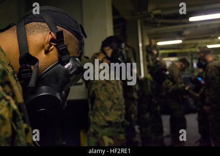 Marines mit Hauptsitz und Dienstleistungsunternehmen, Battalion Landing Team 3. Bataillon, 6. Marine Regiment, 24. Marine Expeditionary Unit beteiligen in einem Bohrer, Don und klar ihre themenorientierte schützende Haltung Ausrüstung während an Bord der USS Iwo Jima (LHD-7) 8. Januar 2015. Durchführung der 24. MEU und Iwo Jima amphibisches bereit Gruppe Marinebetriebe in den USA 6. Flotte Bereich der Maßnahmen zur Erhöhung der Sicherheit der Vereinigten Staaten in Europa interessiert. (Foto: U.S. Marine Corps Lance Cpl. Austin A. Lewis) 24. MEU führt MOPP Getriebe Auffrischungskurs 150108-M-QZ288-127 Stockfoto