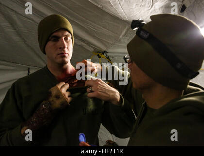 Petty Officer 2. Klasse Frankie Segura, ein Lehrer mit 2. Sanitätsbataillons und gebürtig aus Eagle Pass, Texas, gilt Kunstblut auf einem simulierten Unfall um seine Wunden, während Feld Übung Betrieb Schutzengel an Bord der Marine Corps Base Camp Lejeune, North Carolina, 15. Januar 2015 realistisch erscheinen zu lassen. Um Patienten zu behandeln schnell und effizient, die Sanitätern eine medizinische Zelt aufgestellt, inklusive eine chirurgischen Suite als vorwärts wiederbelebende Surgical System bezeichnet. (U.S. Marine Corps Foto von Lance CPL Michelle Reif/freigegeben) 2. Med BN Züge, Leben zu retten, während der Operation Gu Stockfoto