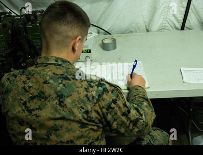 CPL. Travis Lord, ein Feld-Funker mit Bekämpfung der Logistik-Regiment 25, 2. Marine Logistics Group, schreibt in einem Logbuch der Kommunikation während eines Zelt-Trainings an Bord Camp Lejeune, North Carolina, 28. Januar 2015. Marines mit CLR-25 führte die Zelt-Übung, um ihre Fähigkeiten in der Kommunikation während des einwöchigen Trainings weiter. Die Marines durchgeführt eine kurze Arbeit für die Ausübung von sich mit dem Getriebe eine Woche vor der Veranstaltung vertraut zu machen. Marines von CLR-25 arbeitete mit Marines von liefern Bataillon und Wartung Bataillon Informationsübertragung hin und her.  (US Marine Co Stockfoto