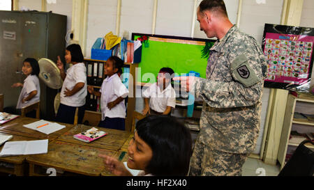 Soldaten der US-Armee der 176th Engineering Company, zusammen mit Ingenieuren der Royal Thai Air Force und des indonesischen Marine Corps, nehmen an der Übung Cobra Gold 2015 teil, die eine Mehrzweckeinrichtung an der Ban Sub Prik Grundschule in Saraburi, Thailand, errichten, um sich mit Schülern während der Gemeindearbeit zu beschäftigen. Stockfoto