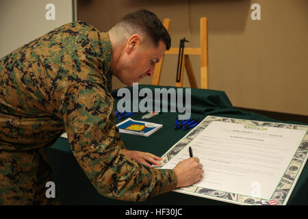 Oberst Robert V. Boucher, Kommandierender Offizier der Marine Corps Air Station Iwakuni, Japan, Zeichen die Verkündigung zur Unterstützung der militärischen spart Wochen während der Informationen fair in Crossroads Mall, 27. Februar 2015. Boucher besucht die Informationen fair zu ermutigen, Bahnhof Bewohner sparen Pläne zu etablieren. Bahnhof Bewohner verpflichten sich, während der militärische speichert Woche 150223-M-HJ625-018 speichern Stockfoto