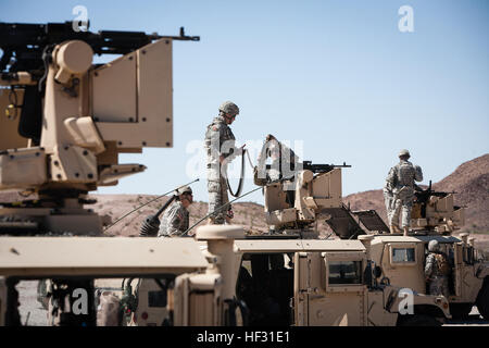 Soldaten der Army National Guard mit 856th Military Police Company in Bellemont, Arizona, Arizona laden Sie Munition in M240B Maschinengewehre montiert auf dem gemeinsamen Remote betrieben Waffen Station II (Krähen II) während Waffen Einarbeitung auf eine Palette an Yuma Proving Ground in Arizona, 6. März 2015. CROWS II wird von sitzen in der M-1151-Humvee Kanonier betrieben, die Ziele erwirbt durch ein Kamera-Monitor anzeigen und per Joystick, um das Waffensystem zu manövrieren. (Foto: US Army National Guard Staff Sgt Brian A. Barbour) 856th Gesellschaft MP führt scharfer Munition ausüben 060315-Z-LW032-006 Stockfoto