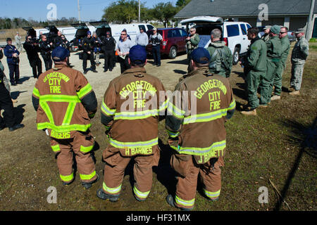 Ersthelfer von Georgetown Rettungsdienst zusammen mit US Armee UH-60 Black Hawk Helikopter-Crews, 2-151. Aviation, S.C. Army National Guard zugewiesen werden um die South Carolina Hubschrauber Aquatic Rescue Team (SC-HART) zivile Kommandanten, Dan McManus, für eine kurze während der wachsam Guard South Carolina Übung in Georgetown, SC, 7. März 2015 gesammelt. Wachsam Guard ist eine Reihe von staatlich geförderten Katastrophenabwehr Bohrer von Einheiten der Nationalgarde in Zusammenarbeit mit Bund, Ländern und Gemeinden Notfallmanagement Agenturen und Ersthelfer durchgeführt. (U.S. Air National Stockfoto