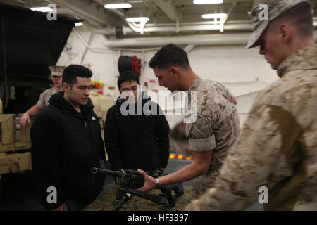 Lance Cpl. Cannon Hering erläutert die Einzelheiten der M249 Squad automatische Waffe um zukünftige Marines, auch bekannt als Poolees, bei einem Rundgang durch die USS Arlington (LPD-24) amphibischen dock Transportschiff, März 14, in South Boston, Massachusetts Hering ist ein motor Transport Operator mit LKW-Spedition, Hauptquartier Bataillon, 2. Marine-Division. Mehr als 100 Marines mit II. Marine Expeditionary Force und US Marine Forces Command segelte nach South Boston, in der Stadt St. Patricks Day Parade zu marschieren. Waffen wissen 150313-M-GF838-002 Stockfoto