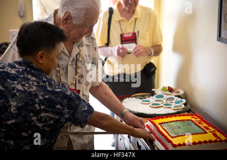 Konteradmiral Bette Bolivar, Kommandant der gemeinsamen Region Marinas und pensionierter Generalleutnant Lawrence Snowden schneiden einen Kuchen mit einem zeremoniellen Schwert während eines Mittagessens Zuhause des Admirals. Die Veteranen gestoppt auf Nimitz Hügel für ein schnelles Mittagessen, Erfrischungen und ein Stück Kuchen während ihrer Tour besuchen Kriegerdenkmäler und Schlachtfelder. Die Gruppe reiste dann nach Iwo Jima, jetzt offiziell bekannt als Ioto, zum Gedenken an den 70. Jahrestag der Schlacht von Iwo Jima. (U.S. Marine Corps Foto von Lance Cpl. Jacob Snouffer/freigegeben) Iwo Jima Veteranen Mittagessen 150319-M-WW824-201 Stockfoto