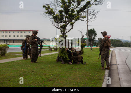 US-Marines mit Battalion Landing Team 2. Bataillon, 4. Marinen, 31. Marine Expeditionary Unit (MEU), eine feindliche Rollenspieler festzuhalten, wie U.S. Marine CPL. Sara M. Ohlms, militärische Hundeführer, 3. Bataillon der Law Enforcement und ihr Gebrauchshund Kuko Sicherheitsleistung während einer nichtkämpfenden Evakuierung im Rahmen der Zertifizierung Übung (CERTEX), auf Lager Hansen, Okinawa, Japan, 22. März 2014. CERTEX ist der kulminierende Fall der MEU jährliche Frühling Patrouille des asiatisch-pazifischen Raum. (US Marine Corps Foto von Gunnery SGT Ismael Pena/freigegeben) 31. MEU führt nichtkämpfenden Evakuierung O Stockfoto