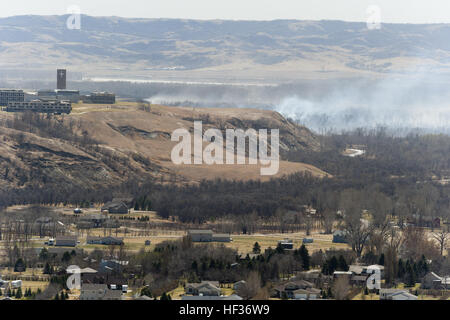 Am Tag nach ein großes Feuer Häuser und Anwesen in Burleigh County bedroht, waren glimmenden Holz und hohe Winde noch ein Anliegen für Feuerwehrleute und Hausbesitzer. Das Feuer begann südlich von Bismarck und North Dakota National Guard Helikopter sank Hunderte von Belastungen von Wasser aus der Luft, während die lokalen Feuerwehren viele Arbeitsstunden auf dem Boden, das Feuer unter Kontrolle zu bekommen. (Nationalgarde Foto von Chief Warrant Officer 4 Kiel Skager, N.D. National Guard Joint Force Headquarters/freigegeben) Süden Burleigh County Wildfire Antwort 041415-Z-BU745-392 Stockfoto