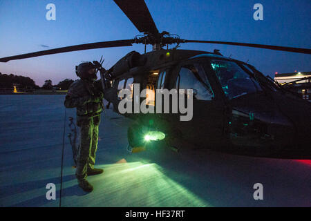 Ein UH-60 Black Hawk Crewchief mit der 1-150. Assault Helicopter Battalion, New Jersey Army National Guard, steht für die Abfertigung für eine Nacht Ausbildungsmission am Joint Base McGuire-Dix-Lakehurst, New Jersey, 21. April 2015. Das 1-150. Angriff Hubschrauber-Bataillon bietet Schlachtfeld Kommandanten die Agilität im Kampf bekommen schneller. Eine gesamten 11 Personen, voll ausgestattete Infanterie-Einheit kann in einer einzigen UH-60 Black Hawk gehoben werden. (U.S. Air National Guard Foto von Master Sergeant Mark C. Olsen/freigegeben) NJ-Guard führt gemeinsame frites training bei JBMDL 150421-Z-AL508-045 Stockfoto
