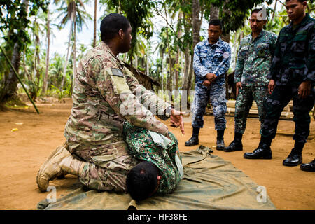 US Army Staff Sgt Jamar Holland, combat Medic mit Delta Company, 97. Civil Affairs Bataillon, Civil Affairs Team 742, weist Mitglieder aus dem philippinischen Marines, Küstenwache und Nationalpolizei überprüfen die Rückseite des Verunfallten für Blut während Tactical Combat Casualty Ausbildung in Puerto Princesa, Philippinen, während des Trainings Balikatan 2015, April 27. Das Tactical Combat Casualty Care Training gelehrt durch US-Streitkräfte, wurde gehalten, um Praxis Techniken effektiv reagieren auf die Krise in der Region. (U.S. Marine Corps Foto von Lance Cpl. Wesley Timm/freigegeben) Philippinischen und amerikanischen F Stockfoto