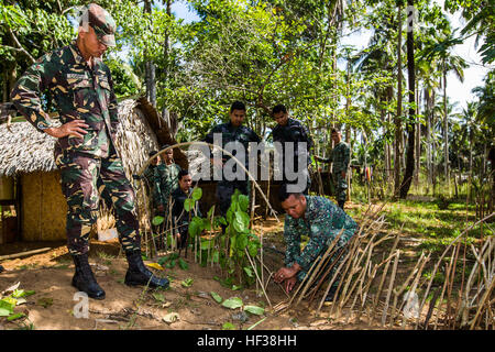 Philippinische Marinekorps CPL. Jose Ryan Tinio, combat Medic mit Battalion Landing Team 4, 3. Marine-Brigade, zeigt militärische Mitglieder teilnehmen im Dschungel überleben Ausbildung wie eine Falle in Puerto Princesa, Philippinen, während des Trainings Balikatan 2015, April 28 zu nutzen. Der Dschungel Survival Training gelehrt durch philippinische Marine Corps wurde gehalten, um militärische Mitglieder beauftragen sowie Techniken effizienter werden als Reaktion auf die Krise in der Region. (U.S. Marine Corps Foto von Lance Cpl. Wesley Timm/freigegeben) Philippine Marines beibringen US-Soldaten in der Ju zu überleben Stockfoto