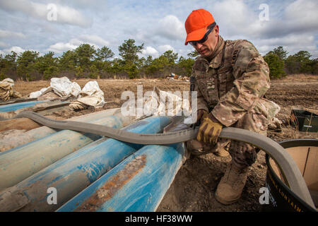 Staff Sgt Joe Coates, 177. Fighter Wing Explosive Ordnance Beseitigung (EOD), New Jersey Air National Guard, schneidet explosive schneiden Band nach der Verlegung es über eine Reihe von inerten BDU-50, 500-Pfund-Praxis Bomben während eines gemeinsamen Render sicheren Betriebs bei Ablösung 1, Warren Grove Gunnery Range, N.J., mit EOD-Flieger aus der 177. und 514. Air Mobility Wing EOD , Air Force Reserve Command, Joint Base McGuire-Dix-Lakehurst, New Jersey, 1. Mai 2015. Die ECT wird verwendet, um durch leer und konkrete Kampfmittel zu schneiden. Ab dem 28. April 2015, EOD-Flieger der Artillerie, die auf der Palette Duri abgeworfen wurde abgerufen Stockfoto