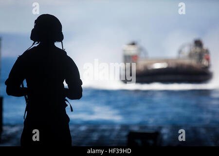 Der Bootsmann Mate 2. Klasse Dennis Lewis Uhren ein Luftkissen Landungsboot gut Deck die amphibischen Transportschiff der Dock USS New York (LPD-21) nach den Transport von 24. Marine Expeditionary Unit Ausrüstung und Personal zugewiesen, um Dschibuti für bilaterale Training mit den Franzosen, 6. Mai 2015 zurück. Die 24. MEU ist auf den Schiffen des Iwo Jima ARG begonnen und wird bereitgestellt, um die Aufrechterhaltung der regionalen Sicherheit in den USA 5. Flotte Einsatzgebiet. (Foto: U.S. Marine Corps CPL. Todd F. Michalek/freigegeben) US Marines trainieren neben französischen Streitkräfte in Dschibuti 150506-M-YH418-009 Stockfoto