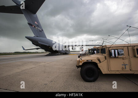 Ein Sturm rollt als Soldaten mit den Headquarters und Headquarters Company, 50. Infanterie Brigade Combat Team, New Jersey Army National Guard, bereiten Humvees auf einer c-17 Globemaster III aus der New York Air National Guard 105. Airlift Wing während ein Bereitstellung-Übung am Joint Base McGuire-Dix-Lakehurst, New Jersey, 11. Mai 2015 zu laden. Die Übung, Teil der Einheit jährliche Ausbildung, war, die Transport-Leistungsfähigkeit des 50. IBCT testen. (U.S. Air National Guard Foto von Master Sergeant Mark C. Olsen/freigegeben) NJNG laden, Fahrzeuge und Soldaten am c-17-150511-Z-AL508-042 Stockfoto