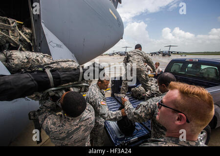 Soldaten mit den Headquarters und Headquarters Company, 50. Infanterie Brigade Combat Team, New Jersey Army National Guard, persönliche Ausrüstung auf eine c-17 Globemaster III aus der New York Air National Guard 105. Airlift Wing während ein Bereitstellung-Übung am Joint Base McGuire-Dix-Lakehurst, New Jersey, 11. Mai 2015 laden. Die Übung, Teil der Einheit jährliche Ausbildung, war, die Transport-Leistungsfähigkeit des 50. IBCT testen. (U.S. Air National Guard Foto von Master Sergeant Mark C. Olsen/freigegeben) NJNG laden, Fahrzeuge und Soldaten am c-17-150511-Z-AL508-093 Stockfoto