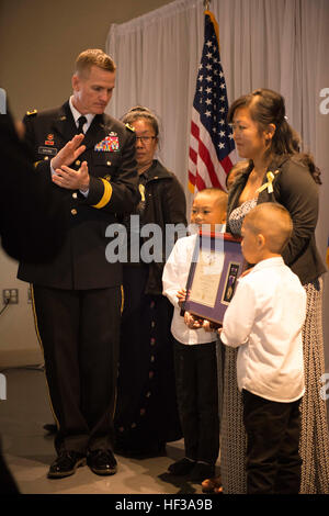 Major General Kent Savre, Fort Leonard Wood Kommandierender general, präsentiert Pfc. Kham Xiong Frau und Söhne mit seinem lila Herzen während einer Zeremonie 14. Mai 2015, in St. Paul, Minnesota Xiong war einer der 13 Personen getötet 5. November 2009, bei einem shooting in Fort Hood, Texas. (Foto: US Army National Guard Sgt. 1. Klasse Ben Houtkooper) Fort Hood schießen Opferfamilie erhält posthume Purple Heart ausgezeichnet 150514-Z-BC699-012 Stockfoto