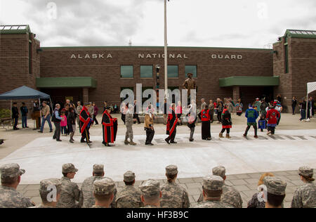 Gouverneur Bill Walker, Zentrum in roten und schwarzen Tlingit Taste Decke, und Vizegouverneur Byron Mallott, links vom Gouverneur, Teilnahme an einer Reinigung und Segen Zeremonie an der Alaska National Guard Armory auf gemeinsamer Basis Elmendorf-Richardson 26 Mai. Die Reinigung und Segen Zeremonie ist eine komplexe und symbolische Veranstaltung, den Geist der Nationalgarde zu beleben, die in der Ehre-Pole, verkörpert wird, die von George Bennett und sein Sohn James Bennett in Sitka, Alaska, Alaska National Guard zu Ehren geschnitzt war Geschichte und Gegenwart Militärdienst, im Hintergrund zu sehen. Alaska National Guard erhält n Stockfoto