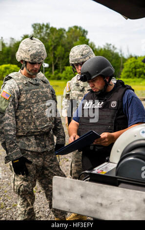 New York Army National Guard Soldaten zugewiesen die dem 1108th Explosive Ordnance (EOD) Entsorgungsunternehmen und ein Offizier aus dem New York City Polizei-Abteilung EOD-Team untersuchen, Röntgenbilder von einem improvisierten Sprengsatz während der Rabe Challenge, EOD Trainingsübung am 25. Juni 2015, im New York State Bereitschaft Training Center in Oriskany, N.Y. Die 2015 zusammengebracht Ravens Herausforderung bei Oriskany EOD Einheiten von der New York Army und der Air National Guard, U.S. Army, Polizeikräfte aus über New York, und militärische und Polizeikräfte aus Kanada. Im Laufe der Woche lange c Stockfoto