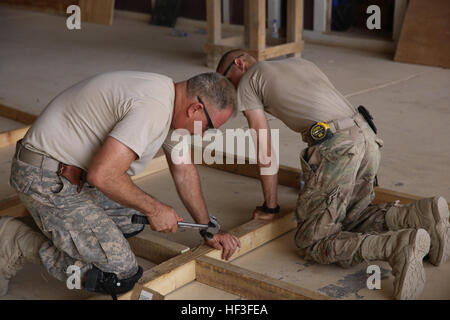 US Army Staff Sgt Joseph Camilleri, links, zugewiesene 315th vertikale Construction Company, 578th Engineer Battalion, 79. Brigade Combat Team, kalifornischen Nationalgarde, arbeitet mit einem anderen Soldaten bei einem Bauprojekt am Al-Taqaddum Luftwaffenstützpunkt, Iraq, 28. Juni 2015. Das Bauunternehmen gebaut Strukturen für das Personal der Task Force Al Taqaddum, ist Teil der kombiniert Joint Task Force – Betrieb innewohnende lösen die beraten und unterstützen Mission. Die A & A-Teams mentor irakischen Sicherheit Kraft Führung in Planung, Logistik und Truppe Betriebsführung in ihrem Kampf gegen die Stockfoto