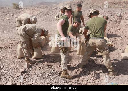 Strand von ARTA, Dschibuti (22. Juli 2015) US-Marines mit dem 15. Marine Expeditionary Unit füllen Sandsäcke um einen Einstiegspunkt für die Steuerung in einem Quartier Durchhaltefähigkeit Training an Land zu konstruieren. Elemente der 15. Marine Expeditionary Unit sind an Land in Dschibuti für Erhaltung Ausbildung zu erhalten und zu verbessern die Fähigkeiten, die sie während ihrer Periode der Einsatzvorbereitenden Ausbildung entwickelt.  Die 15. MEU ist zur Unterstützung von maritimer Sicherheitsoperationen und Sicherheitsbemühungen Zusammenarbeit Theater in der US-5. und 6. Flotte Einsatzgebiete im Einsatz. (U.S. Marine Corps Foto von Steve H. Sgt. Stockfoto