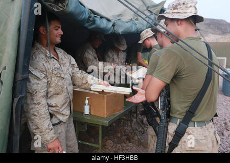 Strand von ARTA, Dschibuti (25. Juli 2015) US Marine Kapitän Edward Gonzales, links, übergibt ein Tablett CPL Aristotle Moran Durchhaltefähigkeit Training. Gonzales ist der Kompaniechef für zentrale und Dienstleistungsunternehmen, Battalion Landing Team 3. Bataillon, 1. Marineregiment, 15. Marine Expeditionary Unit. Elemente des 15. MEU sind an Land in Dschibuti für Erhaltung Ausbildung zu erhalten und zu verbessern die Fähigkeiten, die sie während ihrer Periode der Einsatzvorbereitenden Ausbildung entwickelt.  Der 15. MEU ist derzeit im Einsatz zur Unterstützung der Sicherheit im Seeverkehr Operationen und Sicherheitsbemühungen Zusammenarbeit Theater in th Stockfoto