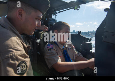 Sgt. John Moreau, eine Flugzeugzelle Mechaniker mit Marine Light Attack Helicopter Training Squadron (HMLAT) 303 und gebürtig aus San Angelo, Texas, überwacht eine AH-1W Super Cobra statische Anzeige während ein Pfadfinder in der Flugzeug-Cockpit in Seattle, Juli 28 sitzt. Mitglieder der Boy Scouts of America tourte statischen Displays an Bord der USS Boxer, wie sie ihre Reise nach Seattle, um die Teilnahme an Seafair Fleet Week abgeschlossen. Seafair Fleet Week setzt Seattle von Angesicht zu Angesicht Navy-Marine Team 150728-M-QU349-013 Stockfoto