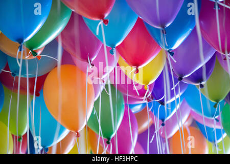 festliche, bunte Luftballons mit Helium-Bindung an den weißen Bändern Stockfoto