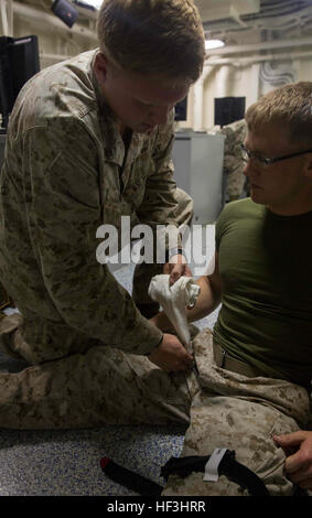 Lance Cpl. Nathan Lynch, ein schweres Gerät-Operator mit der Engineer Detachment, Bekämpfung Logistik-Bataillon 26, 26. Marine Expeditionary Unit (MEU), gilt Bekämpfung Gaze um eine simulierte massive blutende Verletzungen im Bereich Kreuzung auf einen simulierten Unfall während einer Bekämpfung Life Saver an Bord der USS Arlington (LPD 24) 1. August 2015 zu beenden. Marines mit dem 26. MEU und Segler mit der Kearsarge amphibische bereit Gruppe beteiligt sind in Composite Training Unit Übung (COMPTUEX) in Vorbereitung für den bevorstehenden Einsatz, am 5. und 6. Flotte Verantwortungsbereiche später diese fa Stockfoto