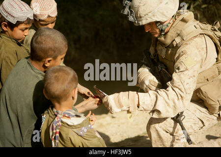 CPL. Kelly Piper mit Waffen Firma, 1. Bataillon, 5. Marineregiment gibt Süßigkeiten zu einer Gruppe von afghanischen Kindern während einer Patrouille in Nawa District, Provinz Helmand, Afghanistan, Okt. 31. Piper ist ein 27-Year-Old amphibische Fahrzeugbetreiber von Denver. Marines mit 1/5, sind Sicherheitspatrouillen durchführen, um mit der lokalen Bevölkerung zu identifizieren, ihre Fragen und Anliegen zu sprechen. 1-5 Marines sorgen für sauberes Wasser, Afghanen, Bereich schützen DVIDS222357 Stockfoto