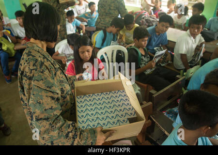 Petty Officer 1st Class Orming Juntereal, Präventives Gesundheitsmanagement Techniker mit 3. Sanitätsbataillons, 3rd Marine Logistics Group, III. Marine Expeditionary Force und gebürtig aus Quezon, Philippinen, gibt Seife, Schülerinnen und Schüler in Palawan, Philippinen, 23. September, während eines Gefechts kooperative Gesundheit (CHE) im Rahmen der amphibischen Landung Übung 2015 (PHIBLEX 15). Das CHE lehrt der philippinischen Gemeinschaft verschiedene präventive Gesundheitsmaßnahmen. Die Matrosen gaben verschiedene Lieferungen, wie Zahnbürsten, Zahnpasta, Seife, Desinfektionsmittel und Notebooks. PHIBLEX15 ist eine jährliche, bilaterale tr Stockfoto