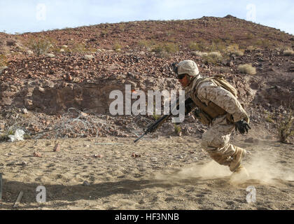 Ein Marine mit 2. Bataillon, 7. Marine-Regiment, 1. Marine-Division, zieht während eines von der Kompanie unterstützten Live-Feuerangriffs im Marine Corps Air Ground Combat Center Twentynine Palms, Kalifornien, am 7. Dezember 2015 in Deckung, als Teil der Marine Corps Combat Readiness Evaluation. Die MCCRE bewertet die Gesamtleistung bei den Missionsanforderungen, um Einheiten für die Entsendung vorzubereiten. Stockfoto