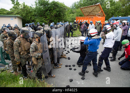 US-Marines und Mitglieder der französischen Gendarmerie bilden eine Mauer von Schilden, einer simulierten US-Botschaft während eines Trainings Aufständen im nationalen Gendarmerie Training Center in St. Astier, Frankreich, 13. Mai 2016 zu schützen. Marines mit speziellen Zweck Marine Air-Ground Task Force-Krise Antwort-Afrika arbeitete eng mit ihren französischen Kollegen zum Austausch von Aufständen Techniken für die realen Szenarien an Botschaften in Europa und Afrika. (U.S. Marine Corps Foto von Sgt. Tia Nagle/freigegeben) Krise Antwort Marines, Französisch Gendarmerie Verhalten Riot Steuern training Stockfoto