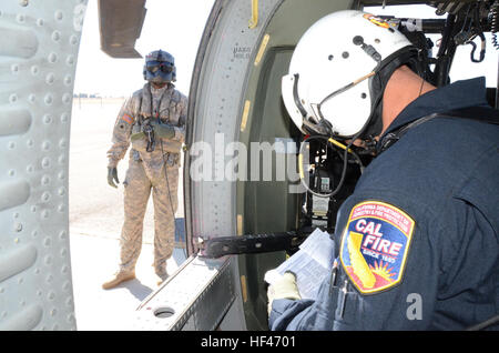 Kalifornien Army National Guard Chief Warrant Officer Two Scott Smith und Bryan Bartucci aus dem 1-140. Aviation Bataillon (Air Assault), mit Sitz in Los Alamitos, fliegen ihre UH-60 Black Hawk, 29. August 2013, von Mather Flight Facility der Dip-Website am See Cherry dam gerade westlich von Yosemite-Nationalpark, 16 verschiedenen Eimer Drop Seiten fünf Minuten entfernt. Die Piloten einziehen, unter der Regie von Cal Fire Manager, Feuer Capt John Zuniga, die Flecken US Forest Service Feuerwehrleute auf dem Boden und signalisiert Spc. Michael Beatty, Crewchief, fallen die Eimer Wasser in der Nähe wo die Stockfoto