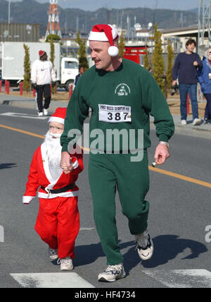 021223-M-9578B-006 Iwakuni, Japan (23. Dezember 2002)--Matrosen, Marines und ihren Familien beteiligen sich an der "2002 Jingle Bell Jog" gesponsert von Marine Corps Community Services an Bord der US-Marine Corps Air Station.  Der Jingle Bell Jog ist eine anderthalb Meile laufen mit Preisen für die besten Kostüme ausgezeichnet.  Die Veranstaltung bietet auch Snacks, Spiele, Gewinnspiele und Spaß für alle Teilnehmer.  US Marine Corps Foto von Lance CPL Alicia J. Brito.   (FREIGEGEBEN) U.S. Navy 021223-M-9578B-006-Matrosen, Marines und ihren Familien zu beteiligen, in dem 2002 Jingle Bell Jog Stockfoto