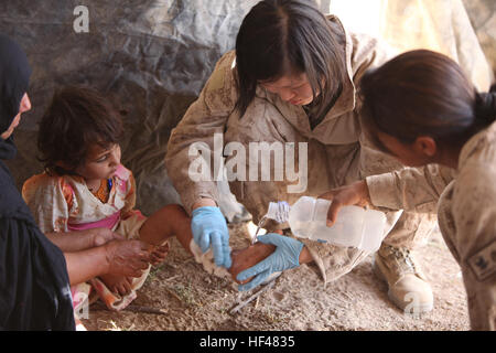 Navy Lt. Jisun Hahn, ein Amtsarzt mit Combat Logistik-Bataillon 5, reinigt ein afghanisches Mädchen Fuß während eines Dorfes medizinische Gefechts, vor den Toren Combat Outpost Reilly, Provinz Helmand, Afghanistan, Juli 10. Hahn ist aus Enid, Oklahoma Marines, Segler bieten medizinischen Versorgung für die afghanischen Frauen, Kinder auf der ganzen nördlichen Marjah DVIDS300405 Stockfoto