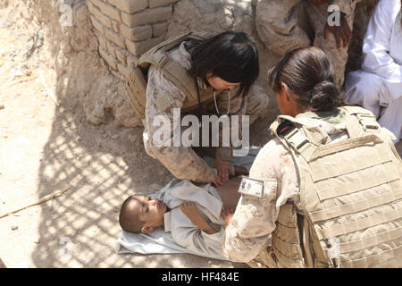 Lt. Jisun Hahn, Amtsarzt und Petty Officer 3rd Class, Liz J. Arevalo Corpsman, beide mit Combat Logistik-Bataillon 5, ich Marine Hauptquartier Group, Blick über ein kleiner Junge zu seiner Krankheit, während ein Dorf medizinische bestimmen Öffentlichkeitsarbeit, 12. Juli, vor den Toren Patrol Base Siapan, Provinz Helmand, Afghanistan. Marines, Segler bieten medizinischen Versorgung für die afghanischen Frauen, Kinder auf der ganzen nördlichen Marjah DVIDS300406 Stockfoto