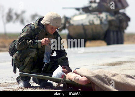 030402-M-3138H-007 Numaniyah, Irak (2. April 2003)--Hospital Corpsman 3. Klasse Christopher Pavicek aus Escondido, Kalifornien, bietet Hilfe für einen verwundeten irakische Soldaten nach einem Feuergefecht mit der 1. Light Armored Reconnaissance Battalion (LAR) außerhalb der Stadt von Numaniyah zur Unterstützung der Operation Iraqi Freedom.  Operation Iraqi Freedom ist das Multi-nationale Koalition bemühen das irakische Volk zu befreien der irakischen Massenvernichtungswaffen beseitigen und das Regime von Saddam Husseins Irak zu beenden.  Foto: U.S. Marine Corps Gunnery Sgt. Erik S. Hansen.  (FREIGEGEBEN) US-030402-M-3138H-007 Marinelazarett Co Stockfoto