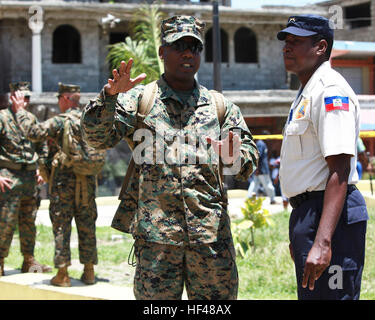 Gunnery Sergeant Felder Domond, gebürtig aus Port-au-Prince, und Versorgung Chef der Bekämpfung Logistik Regiment 27, Logistik Combat Element der Special-Purpose Marine Air-Ground Task Force anhaltende Versprechen 2010 spricht Polycarpe Hugues, haitianische nationale Polizisten während der Eröffnungsfeier der Betrieb weiterhin Versprechen 2010 in Saint-Louis de Nord, Haiti, 26. Juli 2010. In Haiti diente Domond als kreolischer Übersetzer für bedeutende Führungskräfte aus Haiti und die USS Iwo Jima.CP10 ist eine Gemeinschaftsarbeit, die militärische und zivile Personal Bereitstellung humanitärer Hilfe und tät beinhaltet Stockfoto