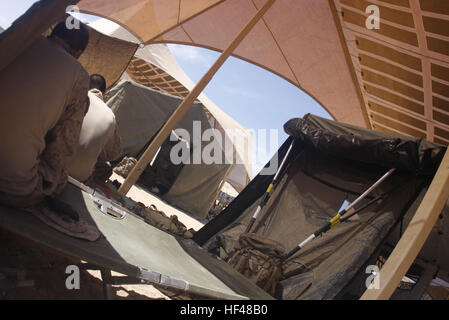 Marines dauern einen Moment zu entspannen und entfliehen Sie der brutalen Mojave-Wüste Hitze unter einer PowerShade bei Combat Center Bereich 220 26 Juli. PowerShade, ist ein Feld mit eingebetteten Solarzellen, die ein bis zwei Kilowatt Energie macht Radios, Laptops, Beleuchtung und Belüftung zu sorgen. Die Marines sind bei uns ich, 3. Bataillon, 5. Marineregiment based out of Marine Corps Base Camp Pendleton, Kalifornien solarbetriebene Teufel Hunde DVIDS305268 Stockfoto