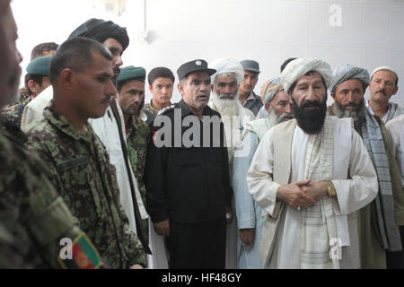 Mitglieder der afghanischen Nationalarmee und lokalen Dorfältesten aus Delaram, Afghanistan, hören wie das Anfangsgebet während der Eröffnung der neuen Filiale der National Bank of Kabul in Delaram, Afghanistan, 10. August 2010 gegeben ist. Die Bank wird 10 Afghanen zu laufen die Filiale sechs Tage, die eine Woche Angebot Geld überweisen, wire Transfer, Debitkartentransaktionen und eine western Union beschäftigen. Kabul Bank eröffnet Niederlassung in Delaram DVIDS310078 Stockfoto