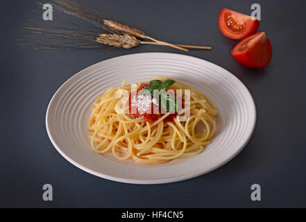 Spaghetti mit Tomatensauce auf grauem Hintergrund Stockfoto