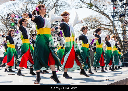 Japanische yosakoi Dance Festival. Männer und Frauen tanzen auf der Bühne in bunten Kostümen. Low Angle View entlang der Tänzer. Stockfoto