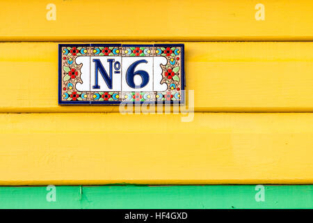 England, Whitstable. Nummer 6 Platte mit Blume Grenze auf vier Kacheln auf Gelb lackiert Platten stecken, mit grünen darunter. Stockfoto