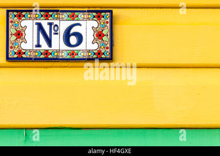 England, Whitstable. Nummer 6 Platte mit Blume Grenze auf vier Kacheln auf Gelb lackiert Platten stecken, mit grünen darunter. Stockfoto