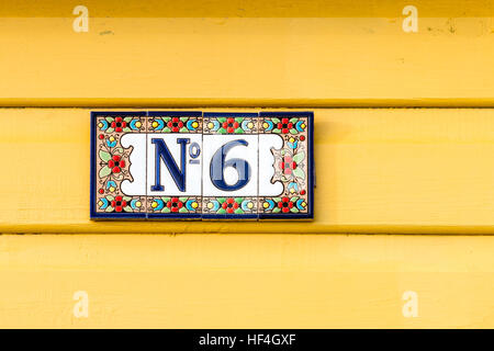 England, Whitstable. Nummer 6 Platte mit Blume Grenze auf vier Kacheln auf Gelb lackiert Platten stecken. Stockfoto