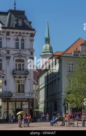 Touristen in der Altstadt von Bratislava in der Slowakei mit dem Turm der St.-Martins Kathedrale im Hintergrund. Stockfoto